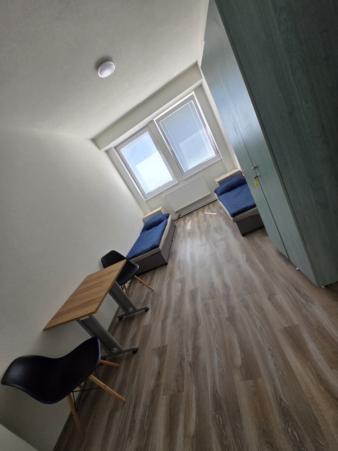 Izba s posteľami a stolom